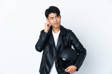 Beyaz arka planda izole edilmiş motosiklet kasklı Çinli bir adam hayal kırıklığına uğramış ve kulaklarını kapatmış.