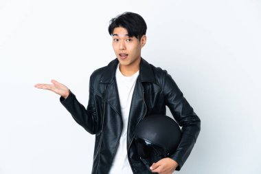 Motosiklet kasklı Çinli bir adam beyaz arka planda izole edilmiş ve şok olmuş bir yüz ifadesi var.