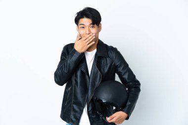 Motosiklet kasklı Çinli bir adam beyaz arka planda izole edilmiş mutlu ve gülümseyen bir ağızla elini kapatıyor.