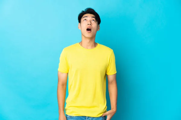 Genç Çinli Adam Mavi Arka Planda Izole Edilmiş Yukarı Bakıyor — Stok fotoğraf