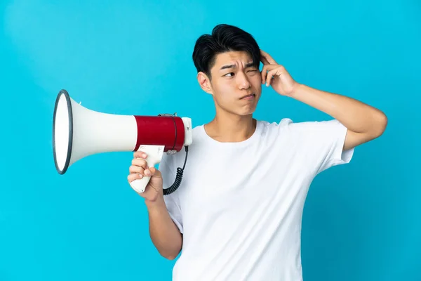 Jonge Chinese Man Geïsoleerd Blauwe Achtergrond Met Een Megafoon Met — Stockfoto