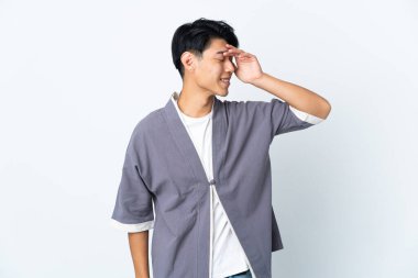 Genç Çinli bir adam beyaz arka planda izole edilmiş, gülümsüyor.