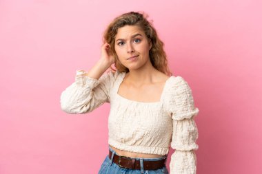 Pembe arka planda izole edilmiş genç sarışın kadının şüpheleri var.