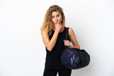 Spor çantalı genç bir kadın beyaz arka planda izole edilmiş düşünüyor.