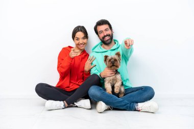 Beyaz arka planda izole edilmiş evcil hayvanlarıyla yerde oturan beyaz bir çift parmak önde.