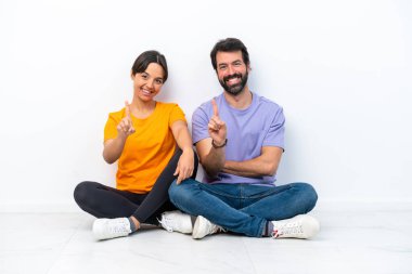 Beyaz arka planda izole bir şekilde yerde oturan beyaz bir çift parmak kaldırıyor.