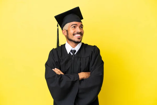Junger Kolumbianischer Universitätsabsolvent Auf Gelbem Hintergrund Isoliert Und Lächelnd Aufblickend — Stockfoto
