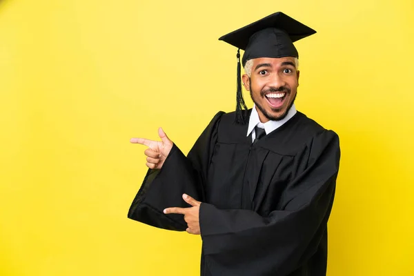 Junger Universitätsabsolvent Kolumbianischer Mann Isoliert Auf Gelbem Hintergrund Überrascht Und — Stockfoto