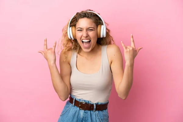 Νεαρή Ξανθιά Γυναίκα Απομονωμένη Ροζ Φόντο Ακούγοντας Μουσική Κάνοντας Ροκ — Φωτογραφία Αρχείου