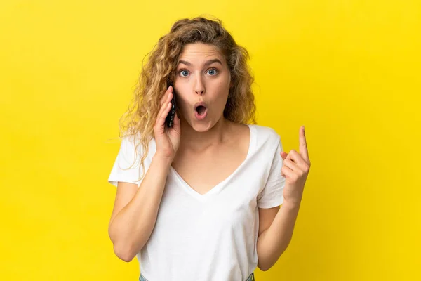 Jovem Loira Usando Telefone Celular Isolado Fundo Amarelo Com Intenção — Fotografia de Stock