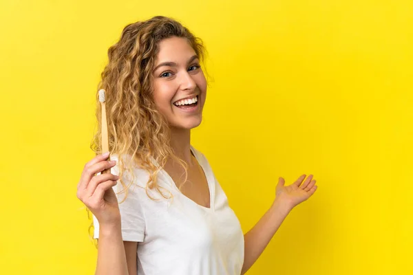 Młoda Biała Kobieta Trzymająca Szczotkujące Zęby Odizolowane Żółtym Tle Wyciągające — Zdjęcie stockowe