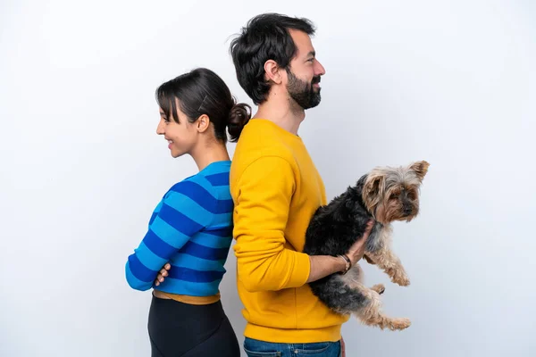 Young hispanic woman holding a dog isolated on white background keeping arms crossed