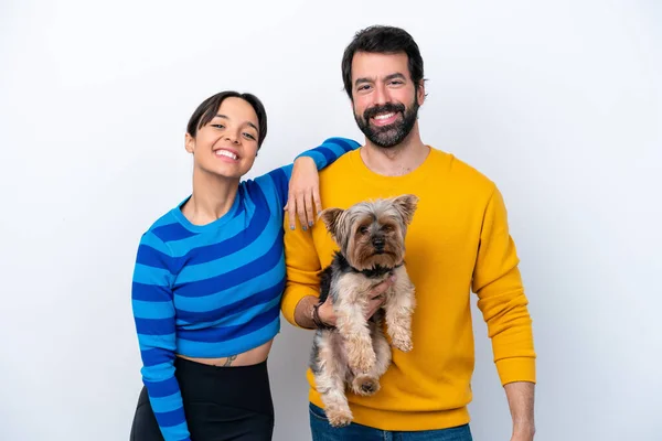 Young hispanic woman holding a dog isolated on white background happy and laughing