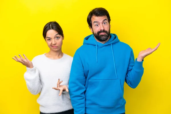 Young Caucasian Couple Isolated Yellow Background Having Doubts Confuse Face — Stock Photo, Image