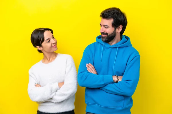 Young Caucasian Couple Isolated Yellow Background Looking Each Other — Stock fotografie