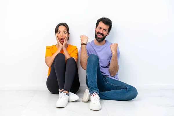 Young Caucasian Couple Sitting Floor Isolated White Background Celebrating Victory — ストック写真