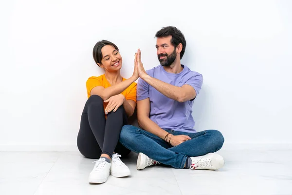 Young Caucasian Couple Sitting Floor Isolated White Background Bumping Hands — Foto de Stock