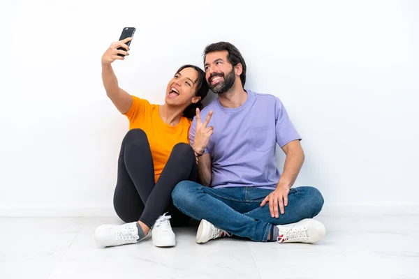 Young Caucasian Couple Sitting Floor Isolated White Background Making Selfie — Stock fotografie