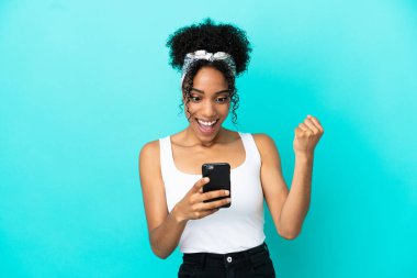 Mavi arka planda izole edilmiş genç Latin kadın şaşırdı ve bir mesaj gönderiyor.