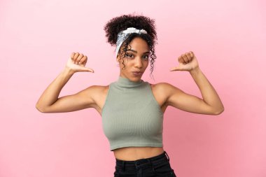 Pembe arka planda soyutlanmış genç Latin bir kadın gururlu ve kendini beğenmiş.