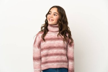 Beyaz arka planda izole edilmiş küçük beyaz kız yukarı bakarken bir fikir düşünüyor.