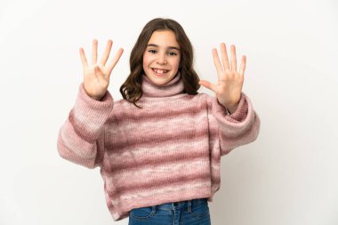 Beyaz arka planda izole edilmiş küçük beyaz kız parmaklarıyla dokuz sayıyor.