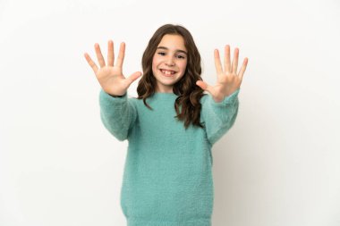 Beyaz arka planda izole edilmiş küçük beyaz kız parmaklarıyla ona kadar sayıyor.