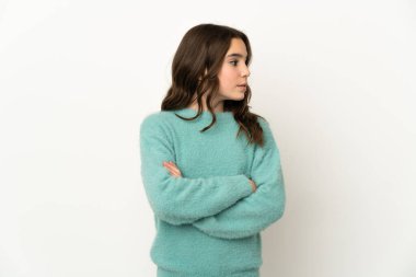 Beyaz arka planda izole edilmiş küçük beyaz kız kollarını kavuşturuyor.