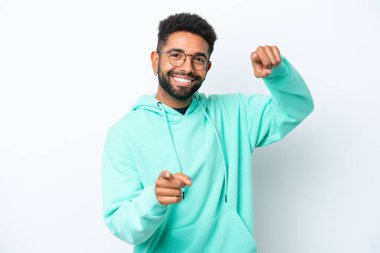 Beyaz arka planda izole edilmiş genç Brezilyalı adam mutlu bir ifadeyle öne bakıyor.