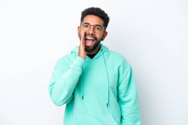 Beyaz arka planda izole edilmiş genç Brezilyalı adam ağzı açık bağırıyor.
