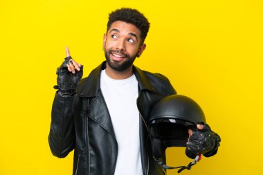 Motosiklet kasklı genç Brezilyalı adam sarı arka planda izole edilmiş.