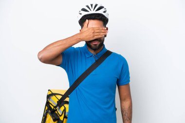 Termal sırt çantalı genç Brezilyalı adam beyaz arka planda izole edilmiş, gözleri elle kapatıyor. Bir şey görmek istemiyorum.