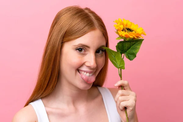 Mulher Ruiva Jovem Isolado Fundo Rosa Segurando Girassol Enquanto Sorri — Fotografia de Stock