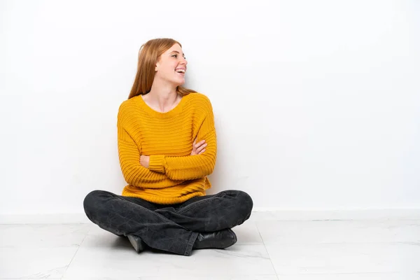 若いです赤毛女性座っています床の上に白い背景に孤立幸せと笑顔 — ストック写真