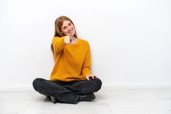 Mladá Zrzka Žena Sedí Podlaze Izolované Bílém Pozadí Ukazuje Prstem — Stock fotografie