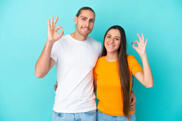 Joven Pareja Caucásica Aislada Sobre Fondo Azul Mostrando Signo Con —  Fotos de Stock