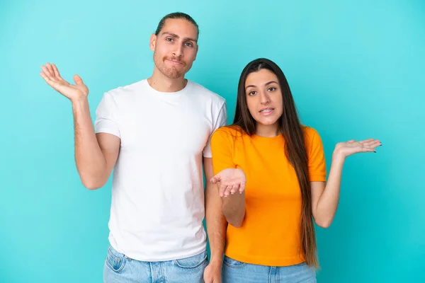 Young Caucasian Couple Isolated Blue Background Having Doubts Confuse Face — Stock Photo, Image