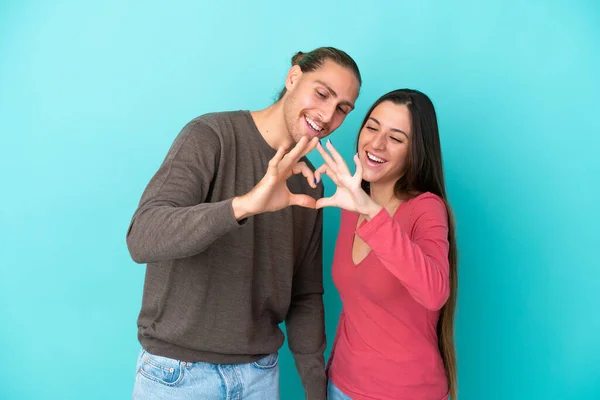 Young Caucasian Couple Isolated Blue Background Making Heart Hands — Stock Photo, Image