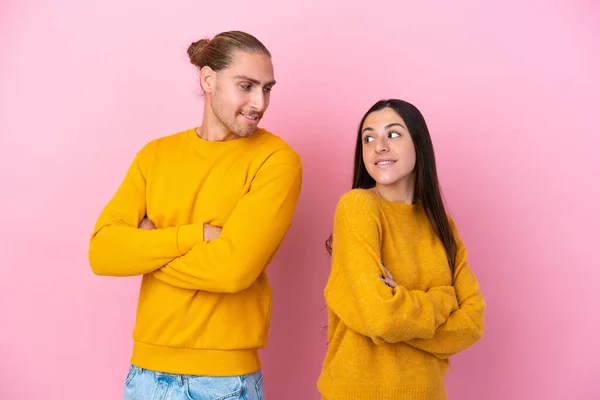 Jovem Casal Caucasiano Isolado Fundo Rosa Olhando Sobre Ombro Com — Fotografia de Stock