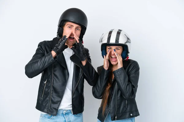 若いですCaucasianカップルとともにオートバイヘルメット隔離上の白い背景叫びと何かを発表 — ストック写真