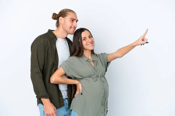 Young Caucasian Couple Isolated White Background Pregnant Pointing Lateral — Stock Photo, Image