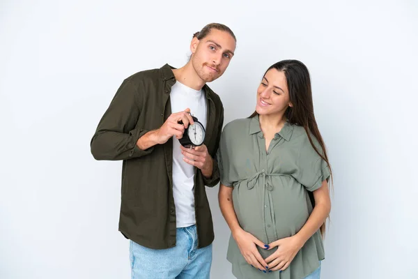 Νεαρό Καυκάσιο Ζευγάρι Απομονώνονται Λευκό Φόντο Έγκυος Και Κρατώντας Ρολόι — Φωτογραφία Αρχείου