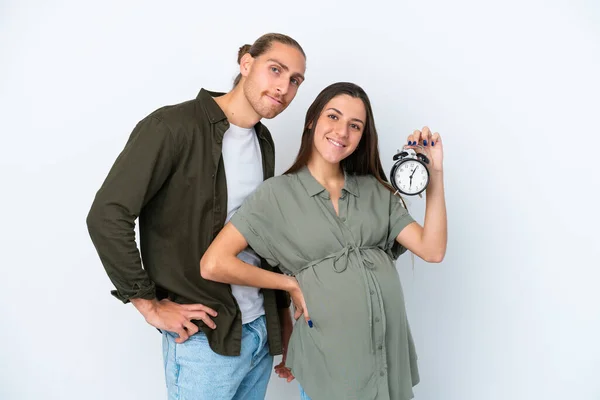 Νεαρό Καυκάσιο Ζευγάρι Απομονώνονται Λευκό Φόντο Έγκυος Και Κρατώντας Ρολόι — Φωτογραφία Αρχείου