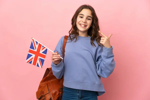 Malá Dívka Drží Vlajku Spojeného Království Izolované Růžovém Pozadí Dává — Stock fotografie