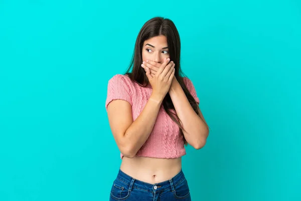 Jovem Brasileira Isolada Fundo Azul Cobrindo Boca Olhando Para Lado — Fotografia de Stock