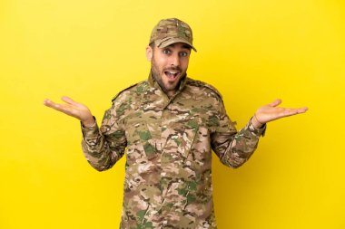 Asker sarı arka planda izole edilmiş, şok olmuş bir yüz ifadesi var.