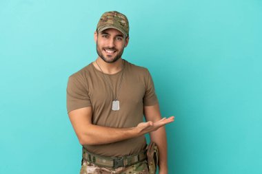 Mavi arka planda izole edilmiş künyeli ordu bir fikir sunuyor ve gülümsüyor.