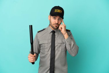 Genç güvenlik görevlisi mavi arka planda bir fikir düşünüyor.