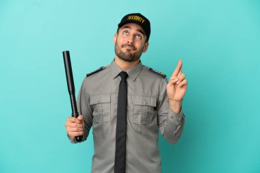 Genç güvenlik görevlisi mavi arka planda izole edilmiş, şans diliyor ve en iyisini diliyor.