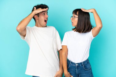 Mavi arka planda, şaşırmış ve şok olmuş bir yüz ifadesiyle soyutlanmış genç bir çift.